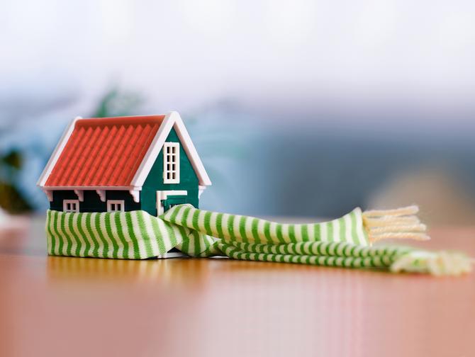 Kleines Haus mit einem grün-weißen Schal Wärme Heizung