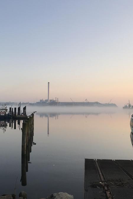 Dämmerung an der Förde mit Spiegelung im Wasser.