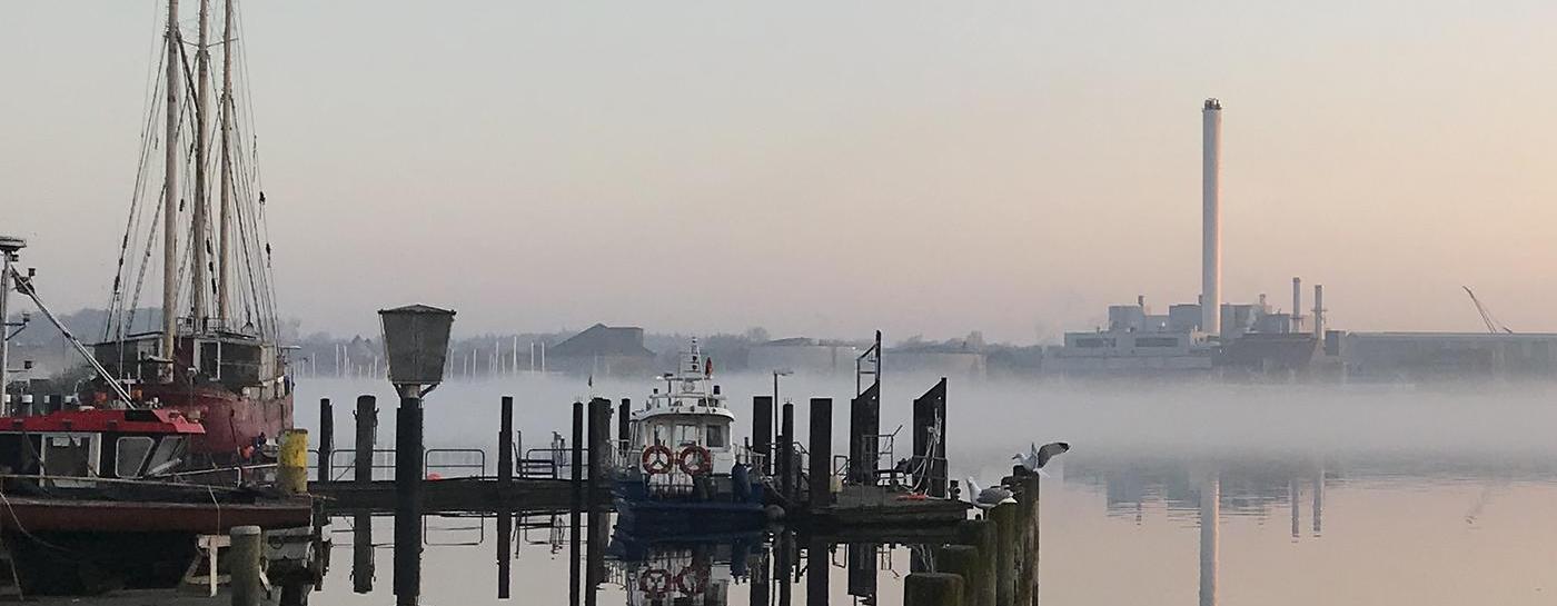 Dämmerung an der Förde mit Spiegelung im Wasser.