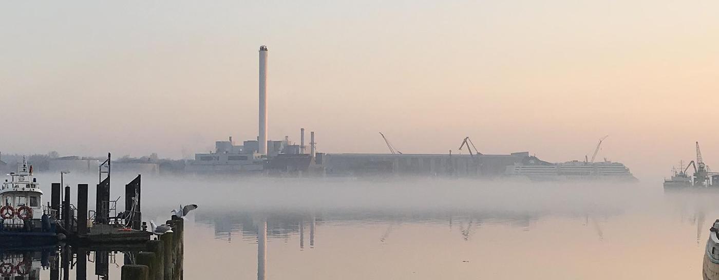 Dämmerung an der Förde mit Spiegelung im Wasser.