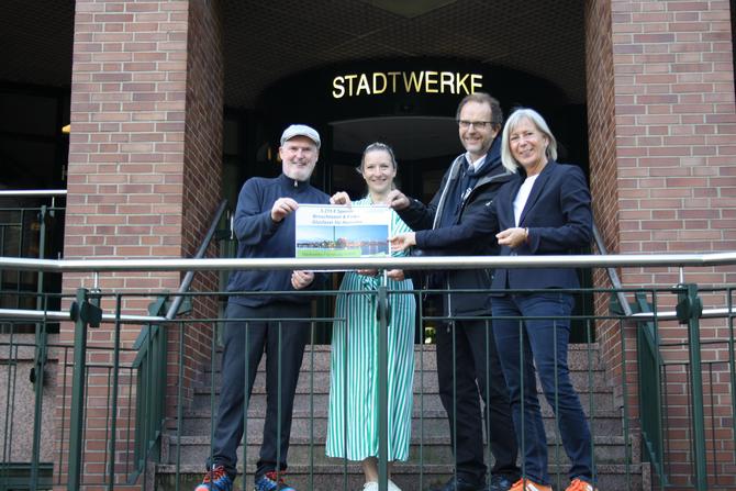 Personen Aufnahme auf der Treppe vor dem Hauptgebäude der Stadtwerke Flensburg. Spende für Broschmann und Finke