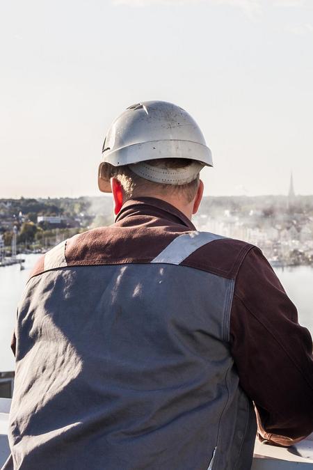 2 Mitarbeiter gucken zur Förde vom Dach des Kraftwerkes