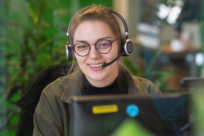 Mitarbeiterin mit Headset im Callcenter