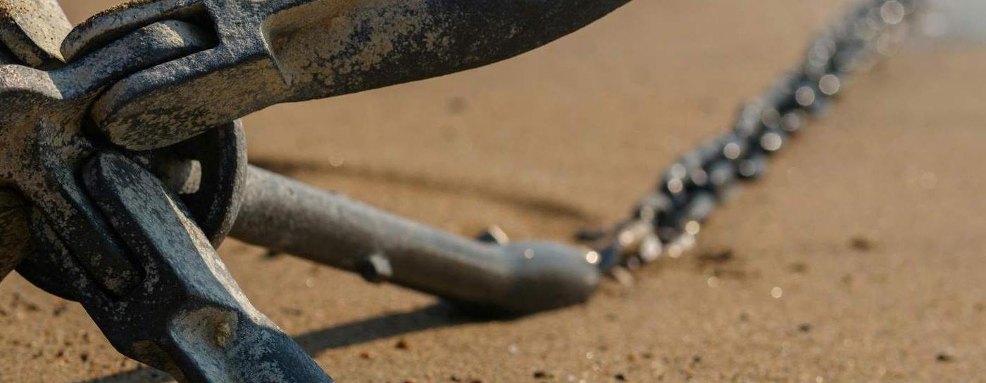 Anker liegt am Strand im Sand