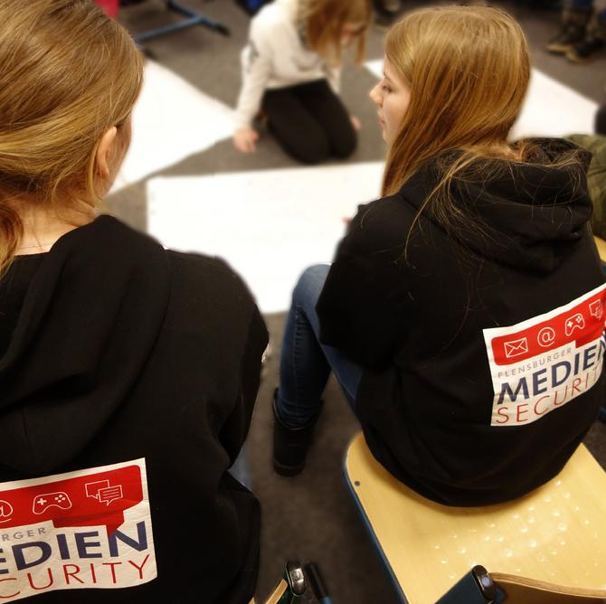 Foto von Frauen im Pullover mit dem Logo der Mediensecurity. 