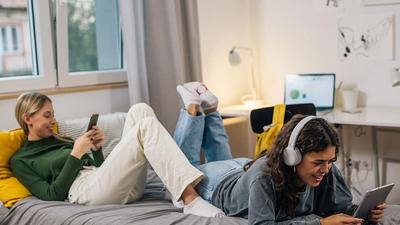 zwei junge Frauen nutzen mobile Geräte