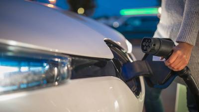 Ein E-Auto wird gerade an den Ladestrom angeschlossen. 
