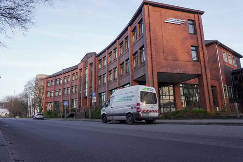 Abbildung des roten Backstein-Hauptgebäudes der Stadtwerke Flensburg von der Straße.