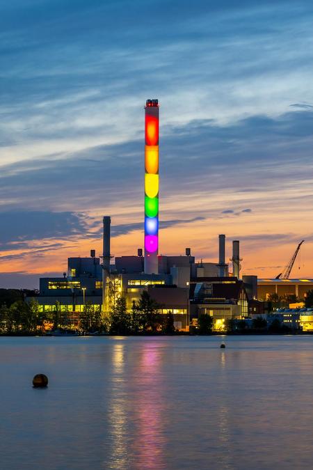 Stadtwerke Flensburg Schornstein in Regenbogenfarben beleuchtet bei Dämmerung. Diversity.
