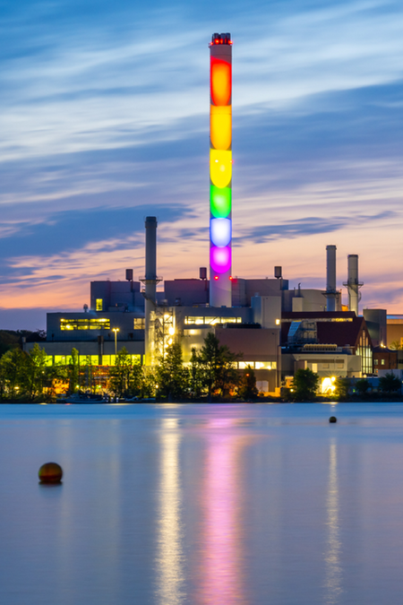 Kraftwerk Schornstein beleuchtet in Regenbogen Farben