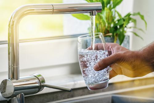 Wasserglas wird mit Flensburger Leitungswasser vom Wasserhahn gefüllt.