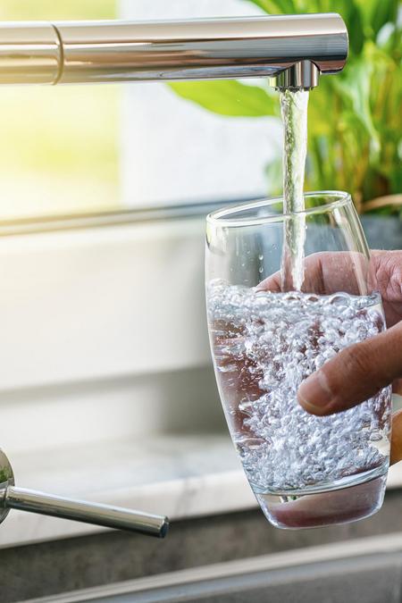 Wasserglas wird mit Flensburger Leitungswasser vom Wasserhahn gefüllt.