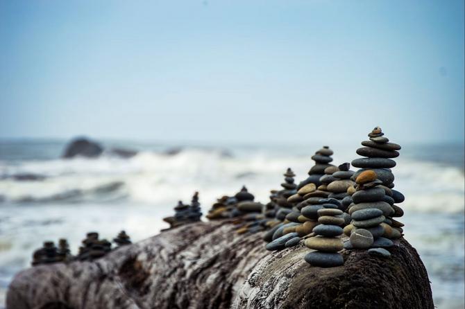 Felsen am Meer mit Steinen daraufgestapelt
