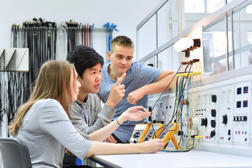 Elektronische Azubis arbeiten zusammen an einer Lösung mit Leuchtmitteln.