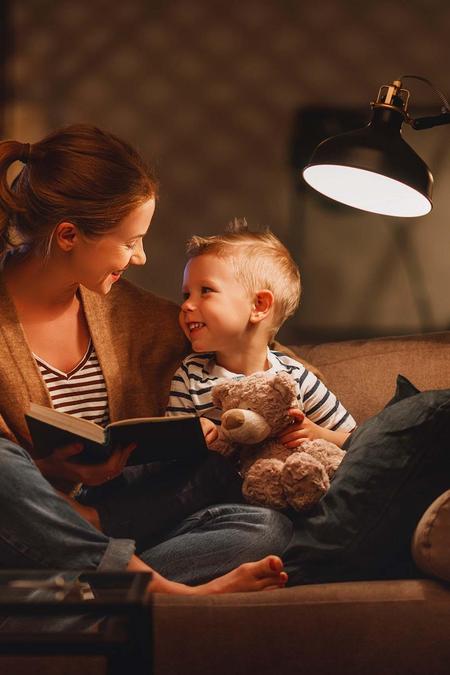 Gemütlich Geschichte lesen auf das Sofa mit Mama, möglich durch Energie der Stadtwerke Flensburg.