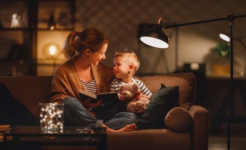 Gemütlich Geschichte lesen auf das Sofa mit Mama, möglich durch Energie der Stadtwerke Flensburg.