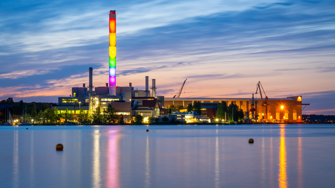 Kraftwerk Schornstein beleuchtet in Regenbogen Farben